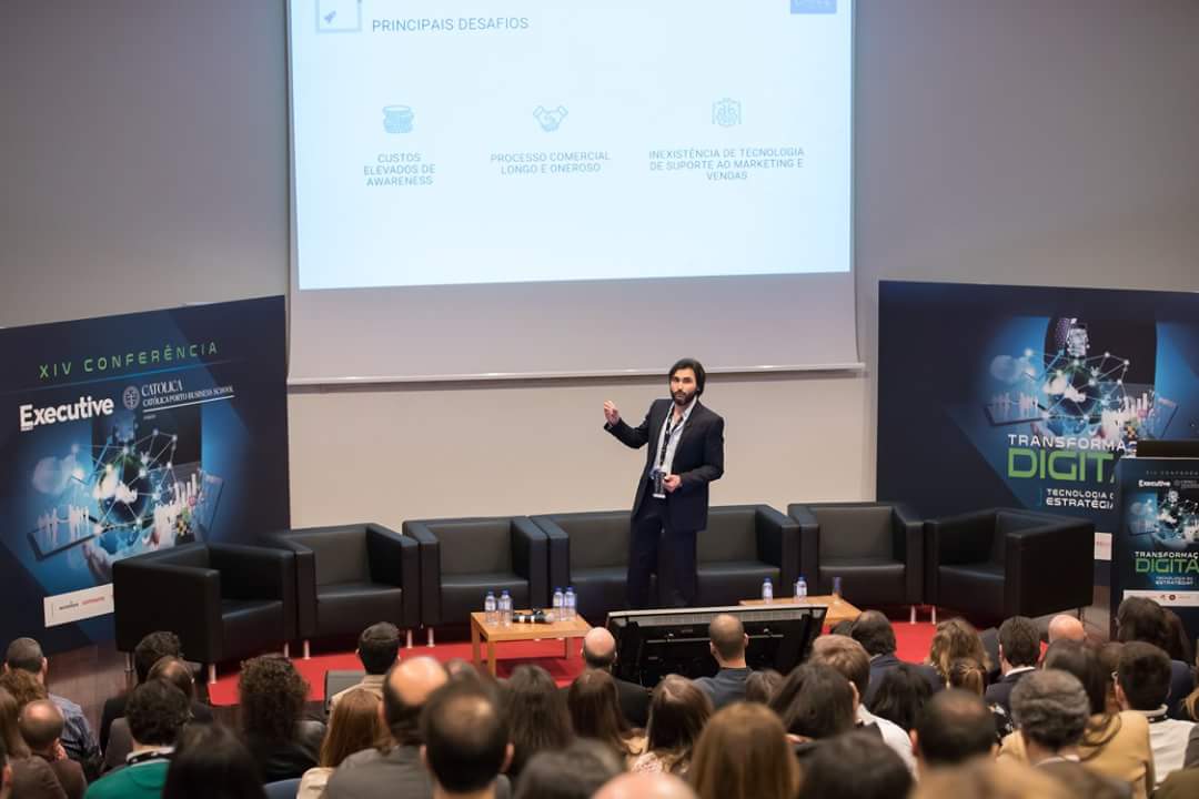 Tiago J. C. Sousa em palco na XIV Conferência Executive Digest, da Católica Porto Business School, com o painel "Transformação Digital: Tecnologia e Estratégia" ao fundo